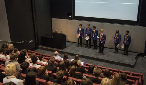 a group of people sitting and standing in front of a crowd