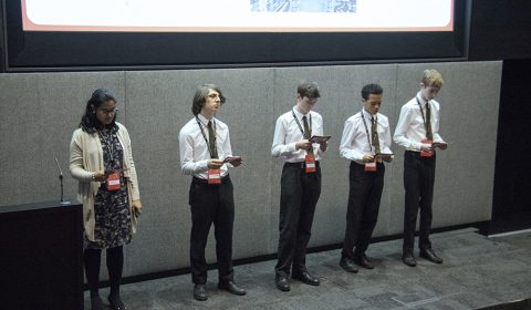 a group of people standing in front of a television
