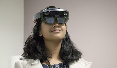 a woman wearing glasses and smiling at the camera
