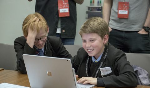 a group of people looking at a laptop