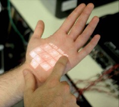 A sensing armband and a pico projector enable interactive elements to be rendered onto a person’s skin.