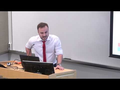 a person sitting at a desk in front of a laptop