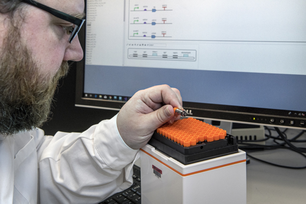 Researcher in Microsoft wet lab examining biological compound