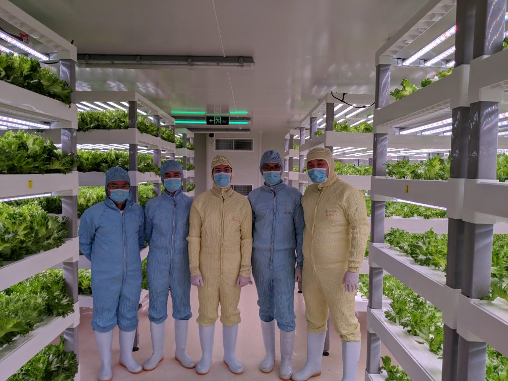 Tran (center) with collaborators from Sananbio at a vertical farm inside the company’s Xiamen, China, facility.