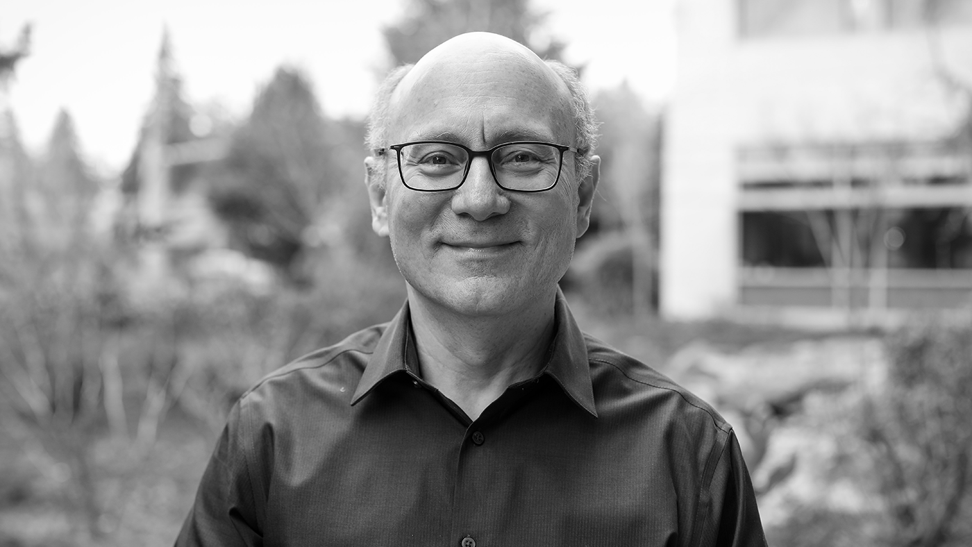 Rico Malvar, Chief Scientist and Distinguished Engineer standing in front of bushes
