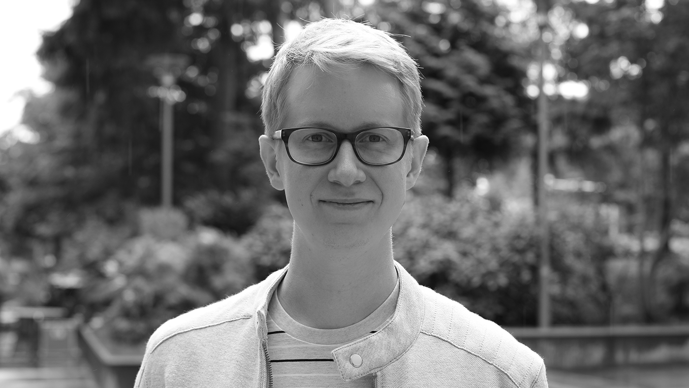 a man wearing glasses and smiling at the camera