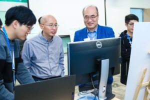 a group of people sitting at a desk in front of a computer