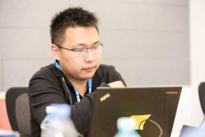 a man sitting at a table using a laptop computer