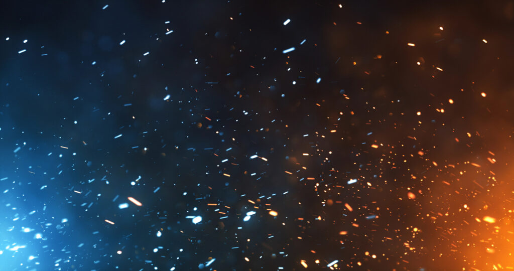 Photo of fire sparks and flame rising in the night air.