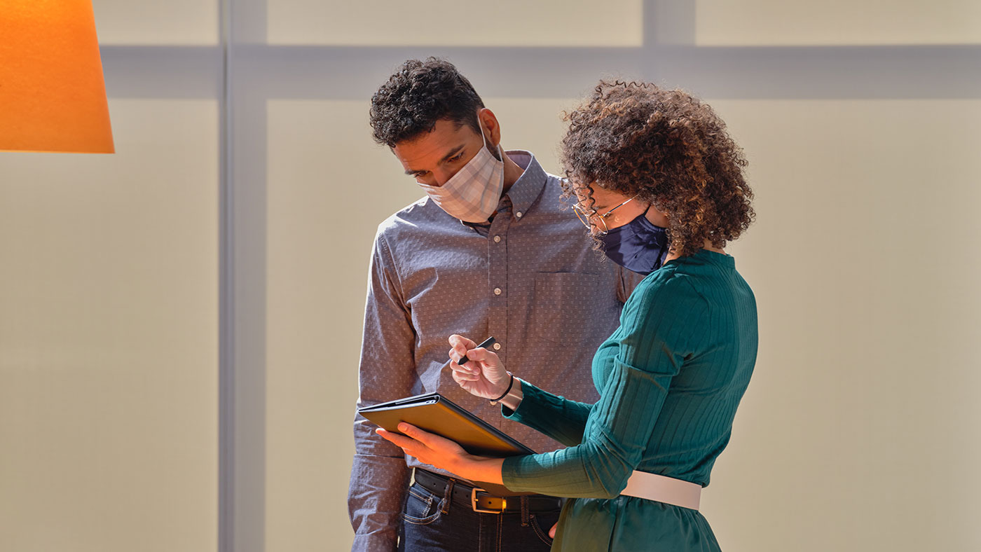 photo of male and female employees reviewing information on a tablet