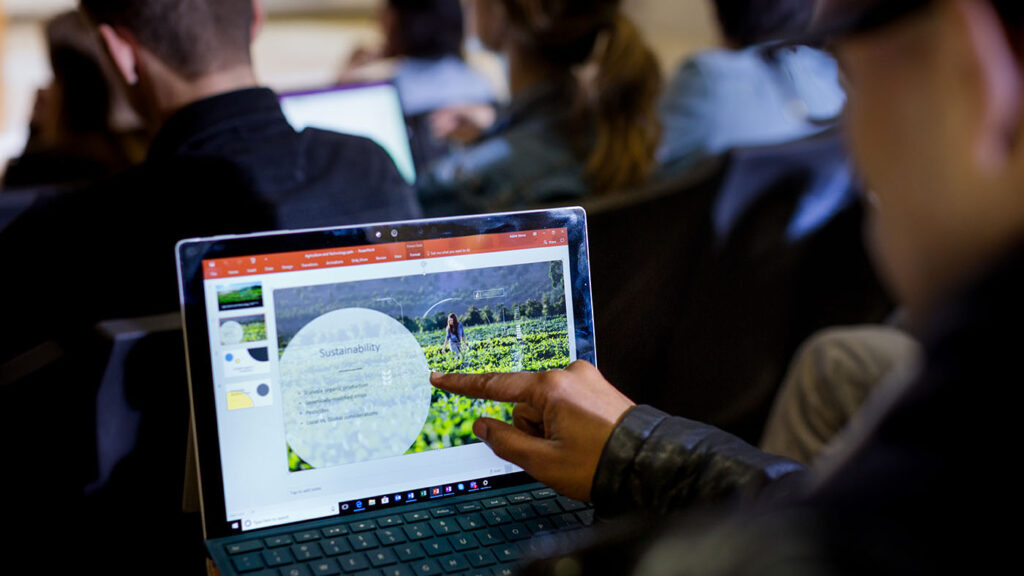 a man using Microsoft PowerPoint on a laptop computer