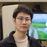 a person wearing glasses and smiling at the camera