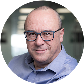 Christopher Bishop wearing glasses and looking at the camera