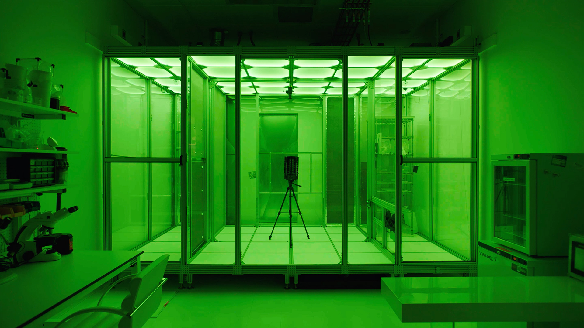 photo of a green-lit containment unit for lab testing