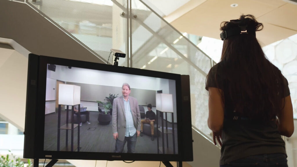 a man and a woman facing each other in a video conference using Living Display
