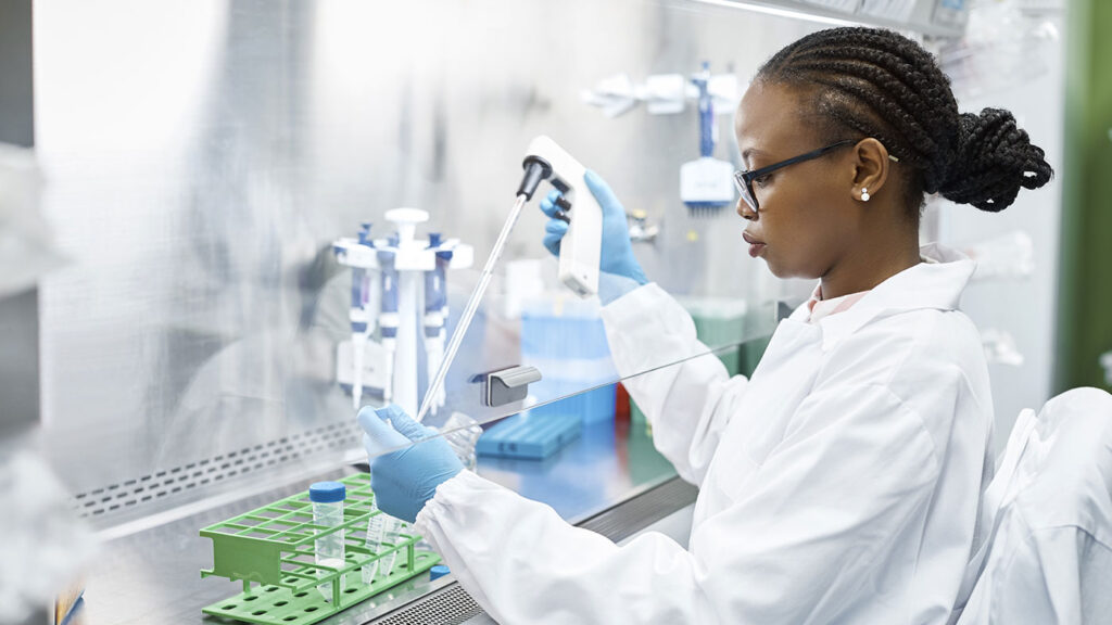 female scientist working in a clean lab pipetting liquid into test tubes
