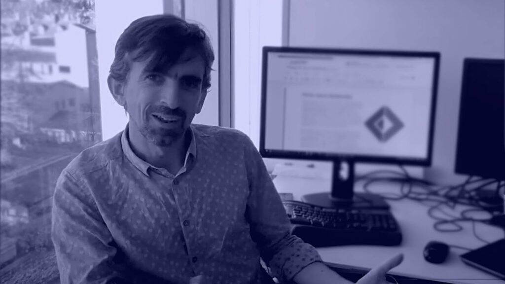 Don Syme standing in front of a computer