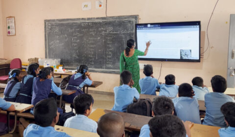 a group of people sitting at a desk in front of a crowd