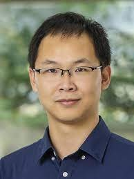 a man wearing glasses and smiling at the camera