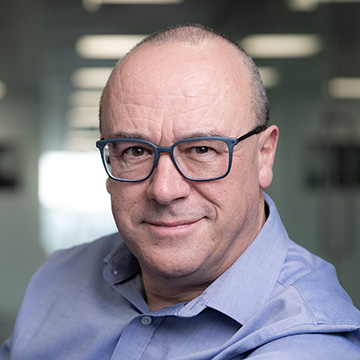 2024 | Christopher Bishop wearing glasses and looking at the camera