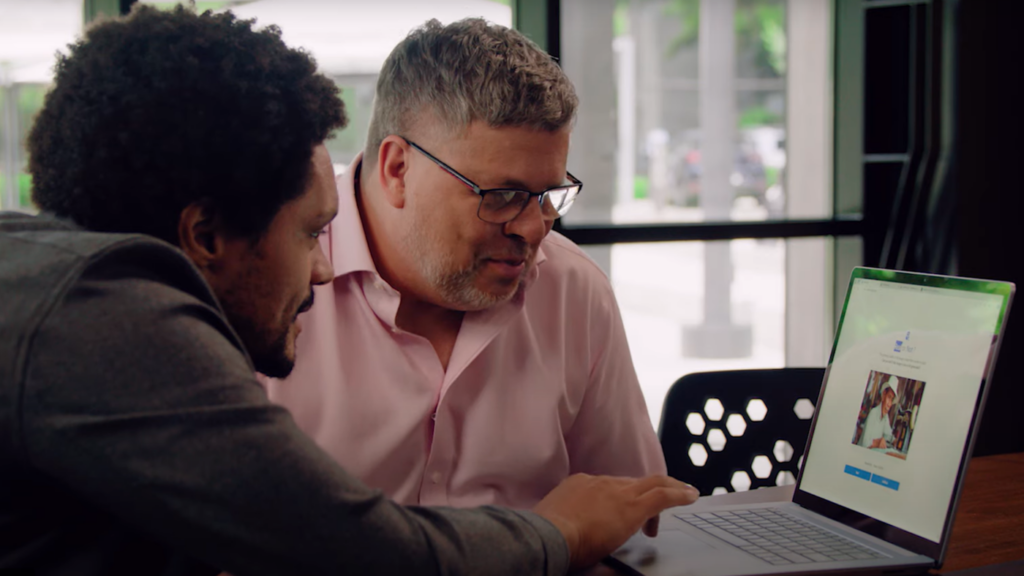 two people looking at an app on a computer screen