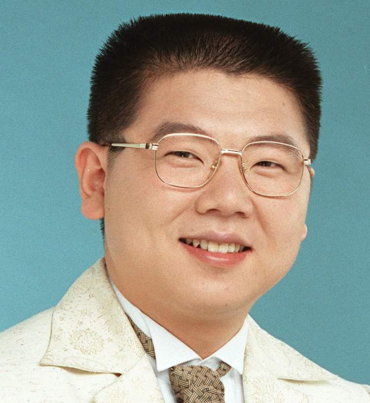 a man wearing glasses and smiling at the camera
