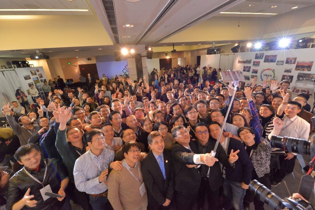 Hsiao-Wuen Hon, Ya-Qin Zhang standing in front of a crowd posing for the camera