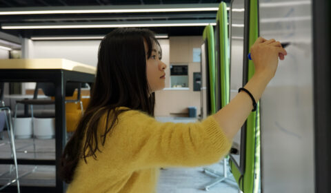 a woman standing in front of a mirror posing for the camera