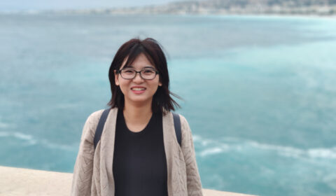 a woman standing in front of a body of water