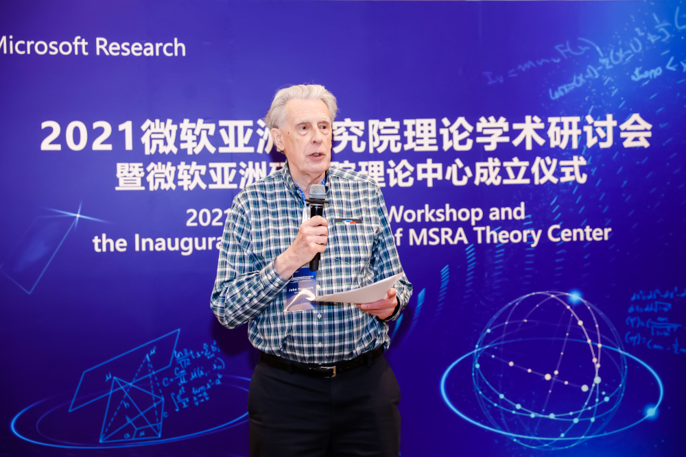 John Hopcroft standing in front of a stage