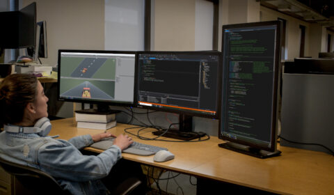 a group of people sitting at a desk in front of a computer
