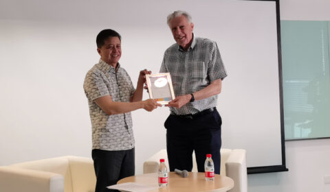 Hsiao-Wuen Hon standing in front of a cake