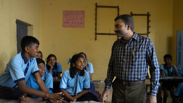 group of students talking to their teacher