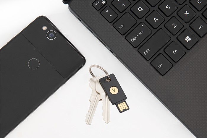An image of a USB key, phone and laptop