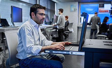 An image of a tech worker on his laptop PC.