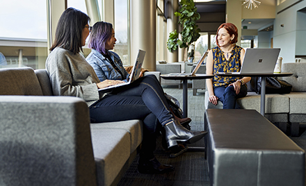 Image of three workers sitting on a sofa.