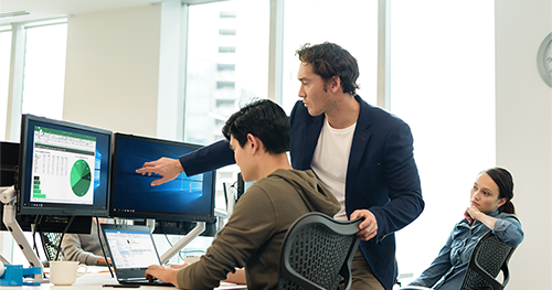 An image of two male and one female worker in open office setting.