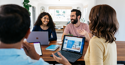 An image of a group of tech workers having a meeting around a table.
