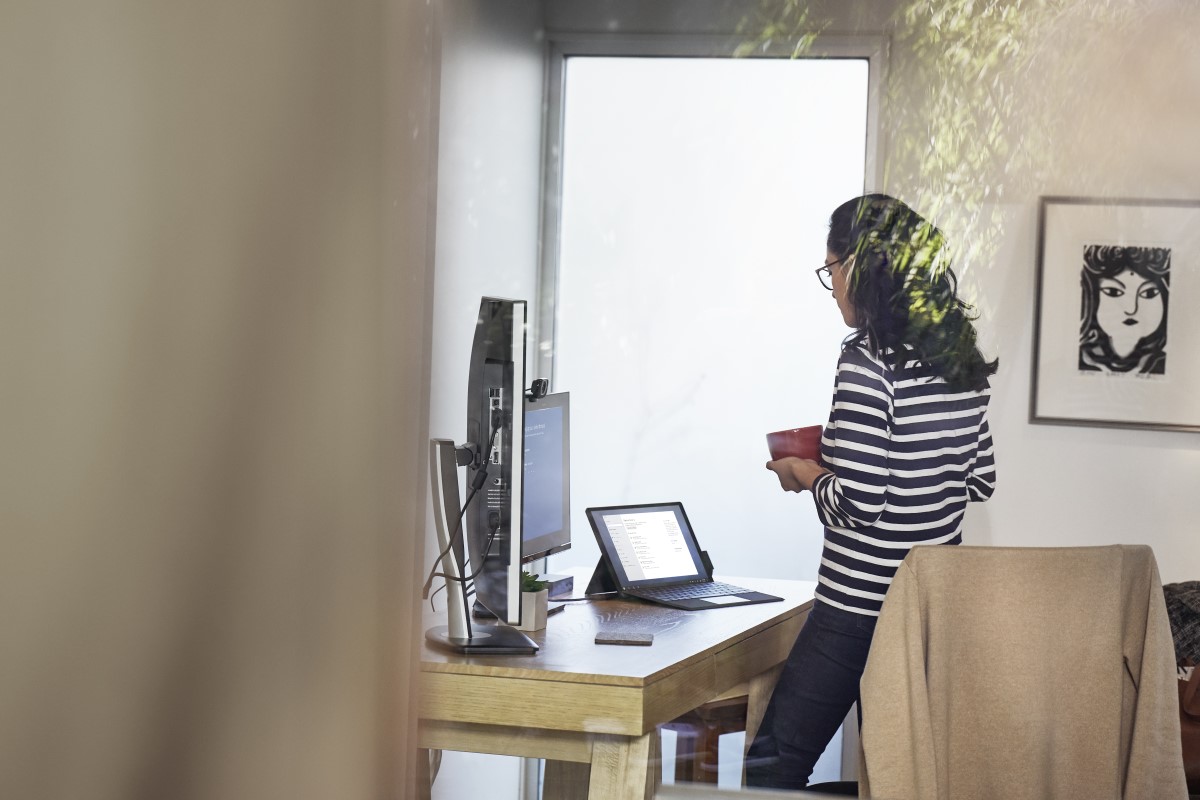 Female working remotely from home office on a Surfce Pro 6 device, standing at desk.