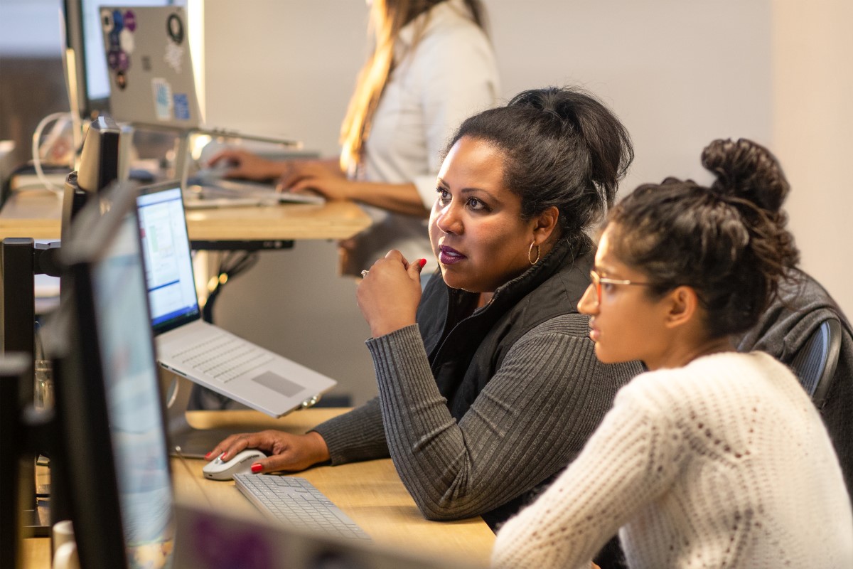 Two female developers collabaorating in their enterprise office space.
