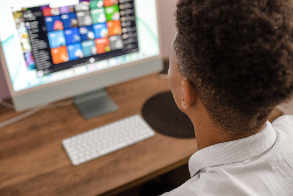 Teenager using desktop computer.