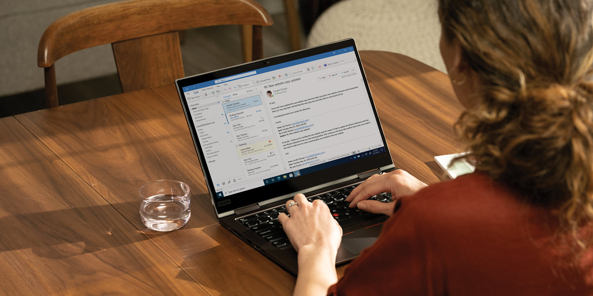 Over the shoulder view of a woman reading emails from her laptop computer.