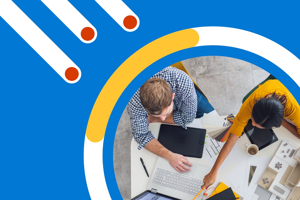 Two people sitting at a desk looking at a computer.