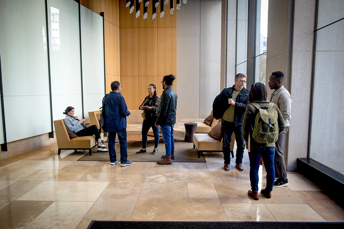 Developers on-the-go, meeting up in the lobby. Male and female developers collaborating outside the office.