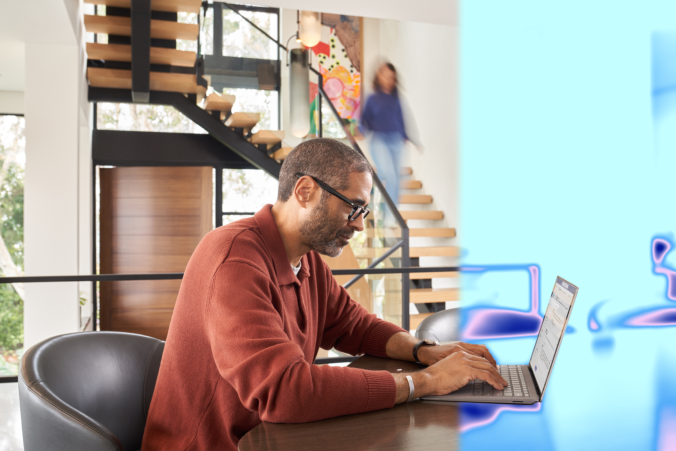 A man sitting at a table using a laptop