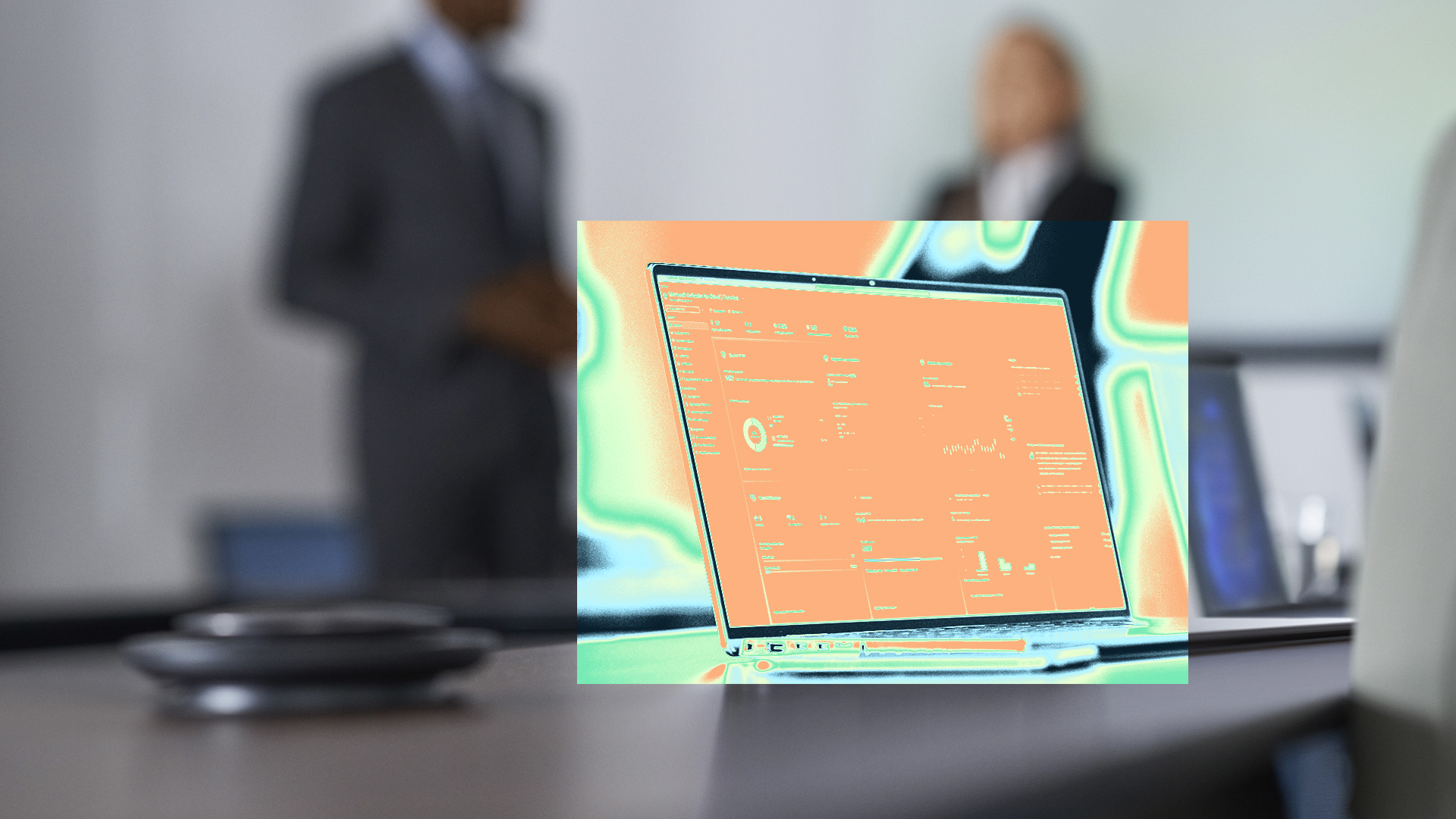 A laptop on a table with two security practitioners standing behind it.
