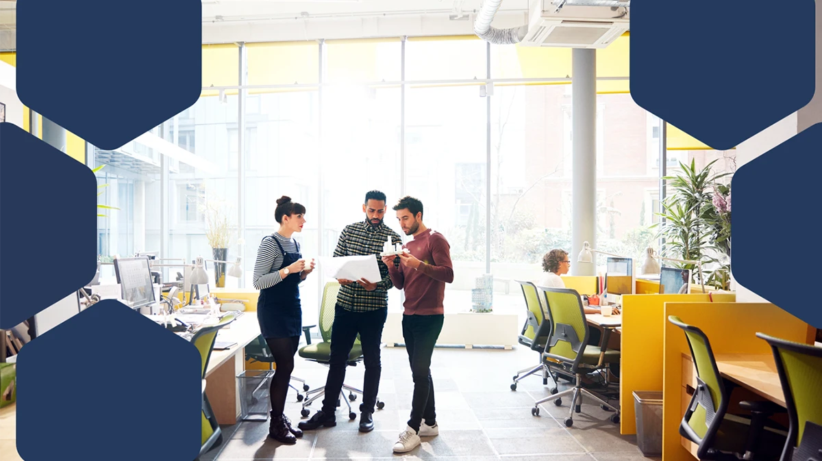 A group of people standing in an office