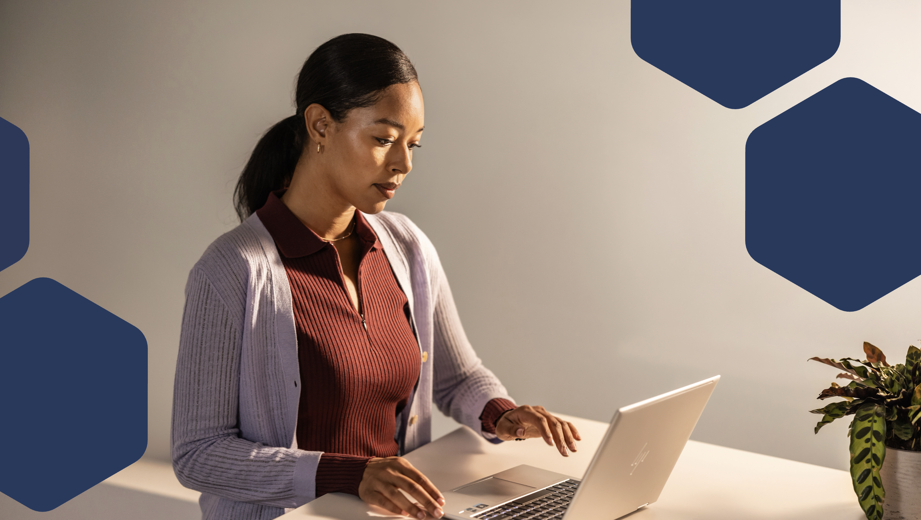 A woman sitting at a desk using a laptop