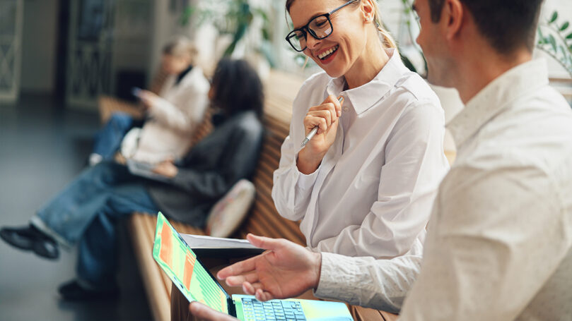 A woman smiling while holding a laptop