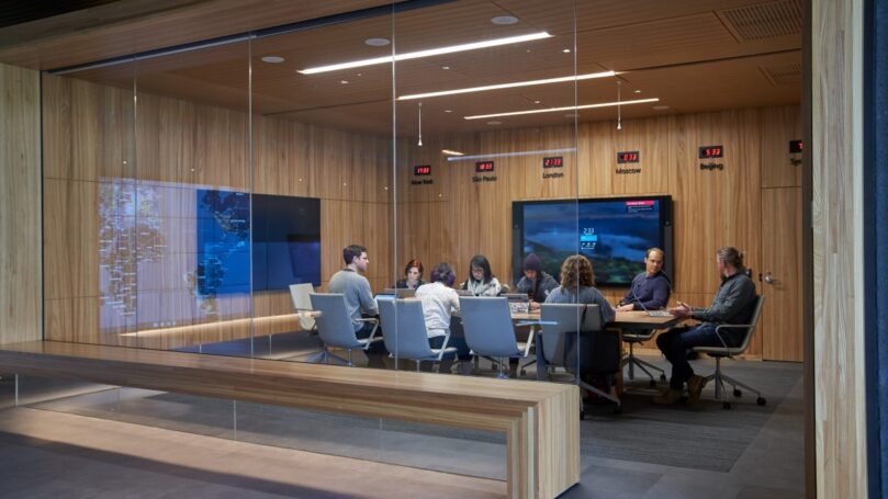 A group of people sitting around a table in a conference room